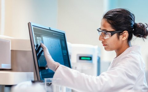 A person in a hazardous materials area looking at a computer screen.