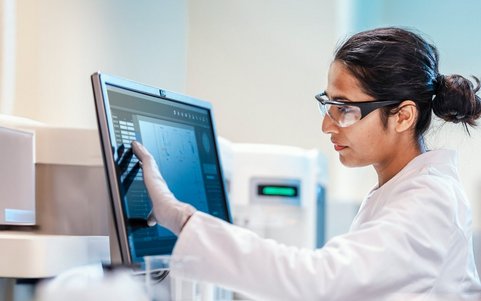 A person in a hazardous materials area looking at a computer screen.