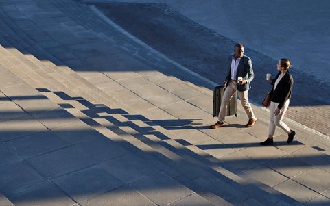Two business professionals walking outdoors.